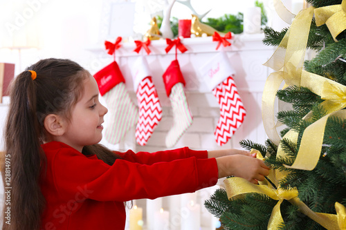 Little girl decorating Chri...