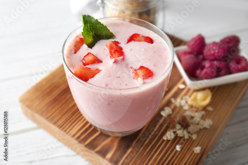 Healthy and tasty breakfast of berry milkshake with mint on wooden board