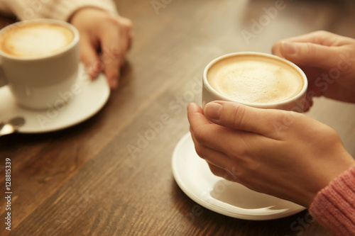 Female hands holding cup of coffee, closeup