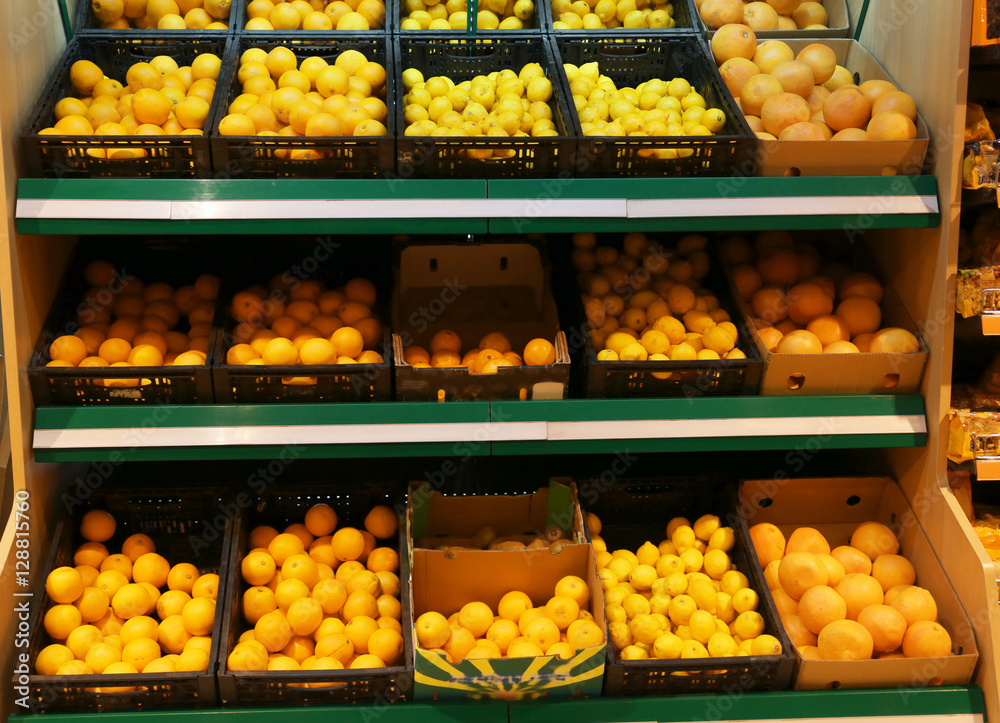 Boxes with fresh citrus fruits in supermarket