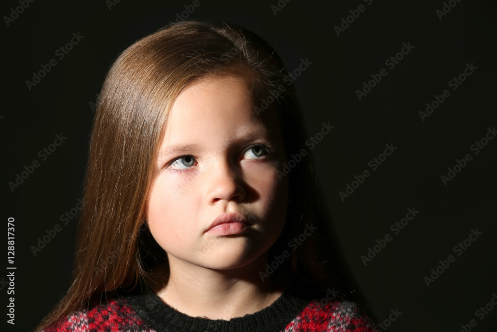 Portrait of cute little girl on black background