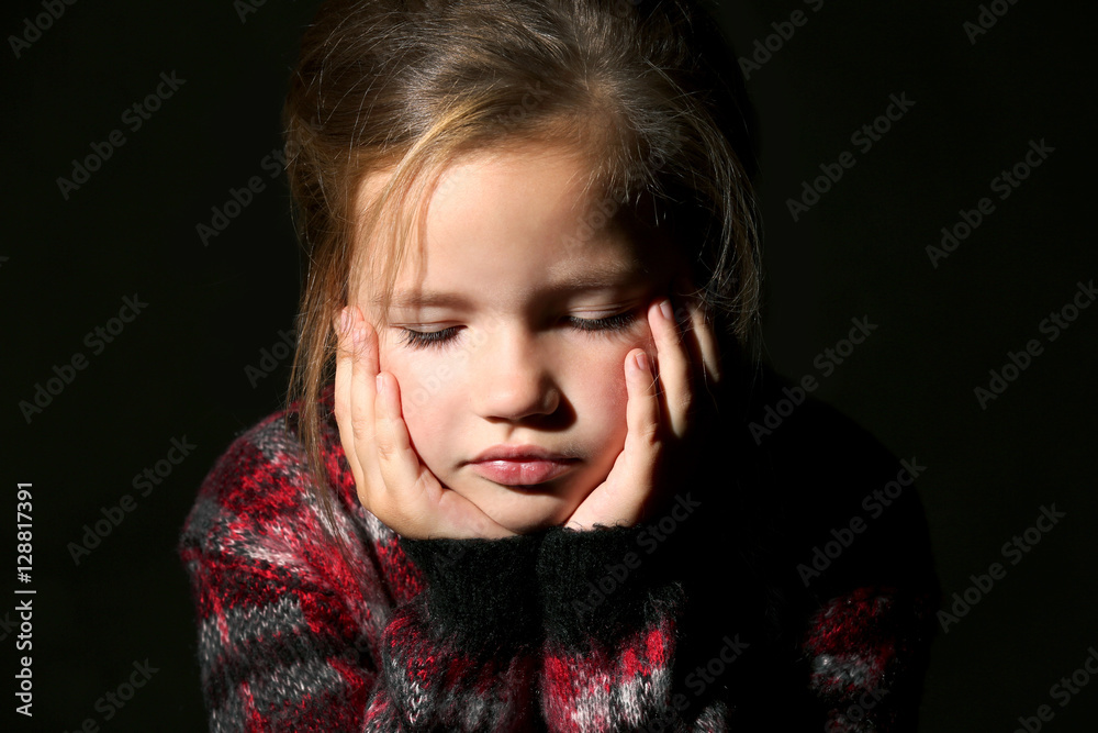 Sad little girl on black background, close up Sad little girl on black background, close up