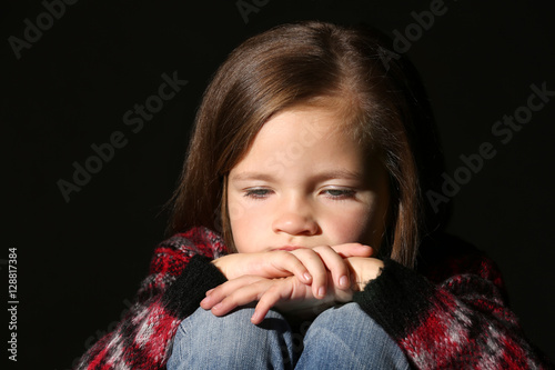 Sad little girl on black ba...