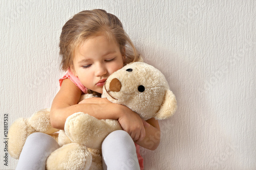 Sad little girl with teddy ...