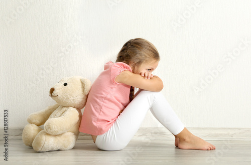 Sad little girl with teddy ...