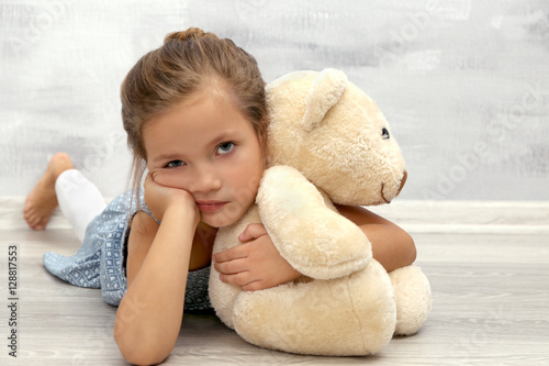 Bored girl with teddy bear ...