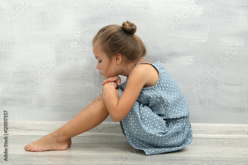 Sad little girl sitting on ...