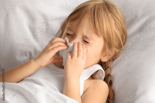 Small sick girl blowing her...