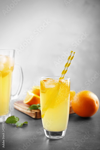 Glass of refreshing orange drink on table