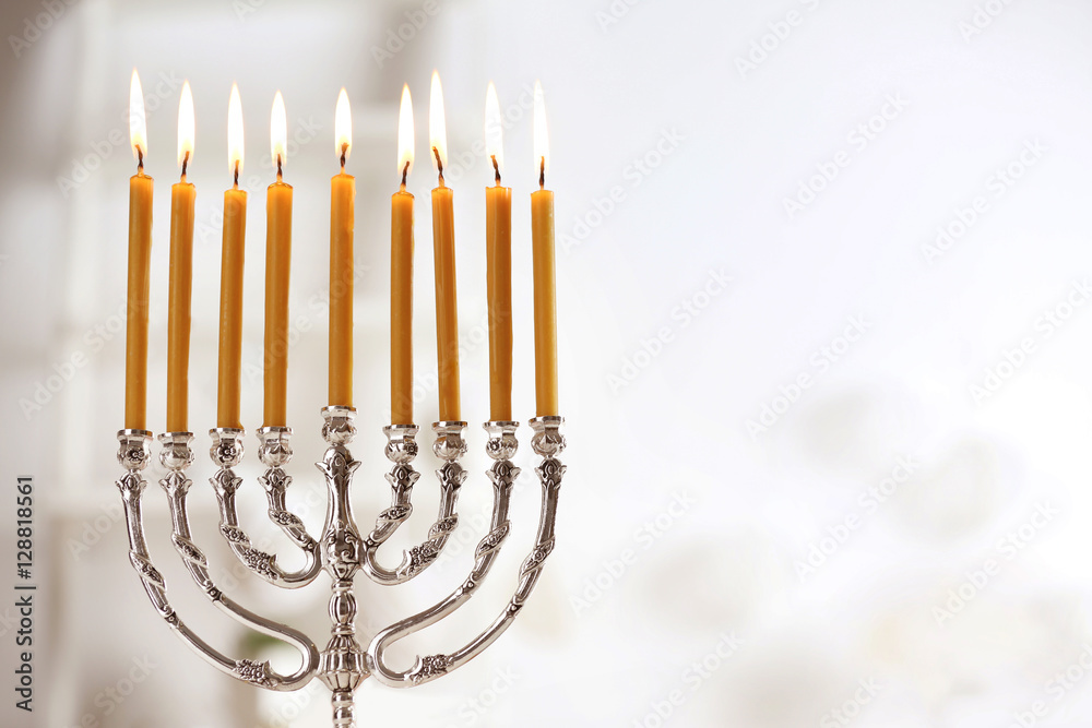 Beautiful menorah with burning candles on light blurred background. Hanukkah concept - obrazy, fototapety, plakaty 