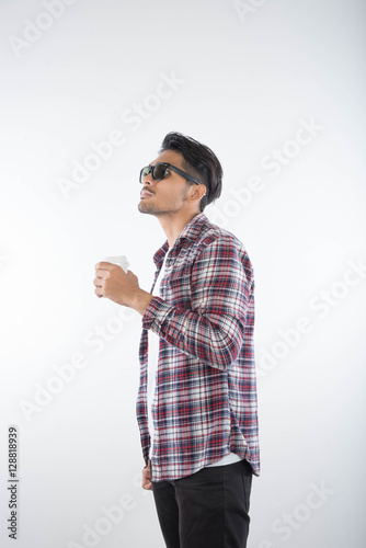 Portrait of happy young man drinking coffice on white background photo