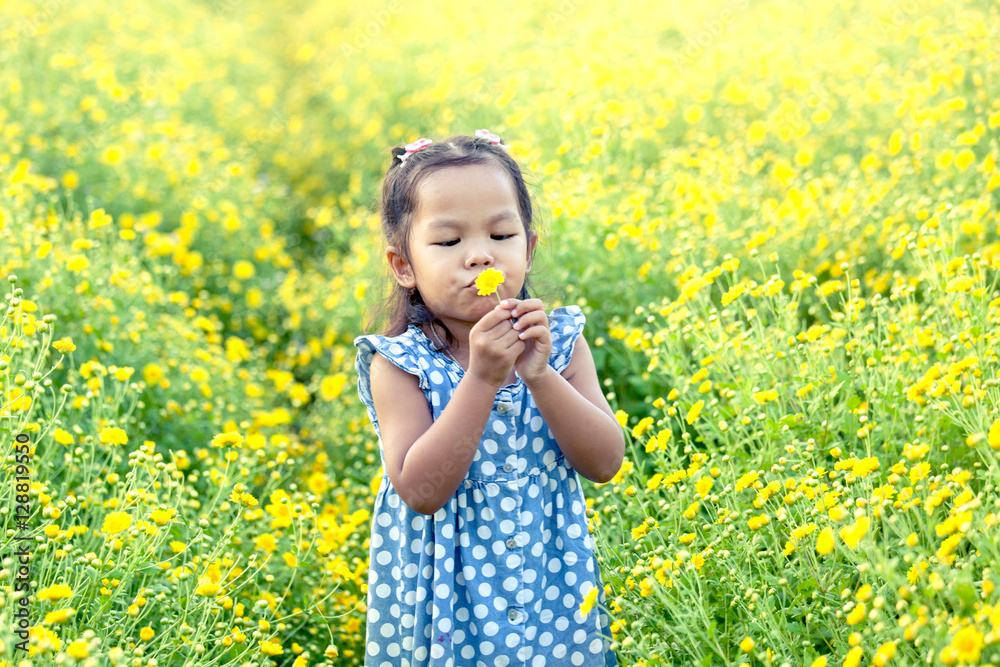 Child asian little girl blowing yellow flower in the garden,havi