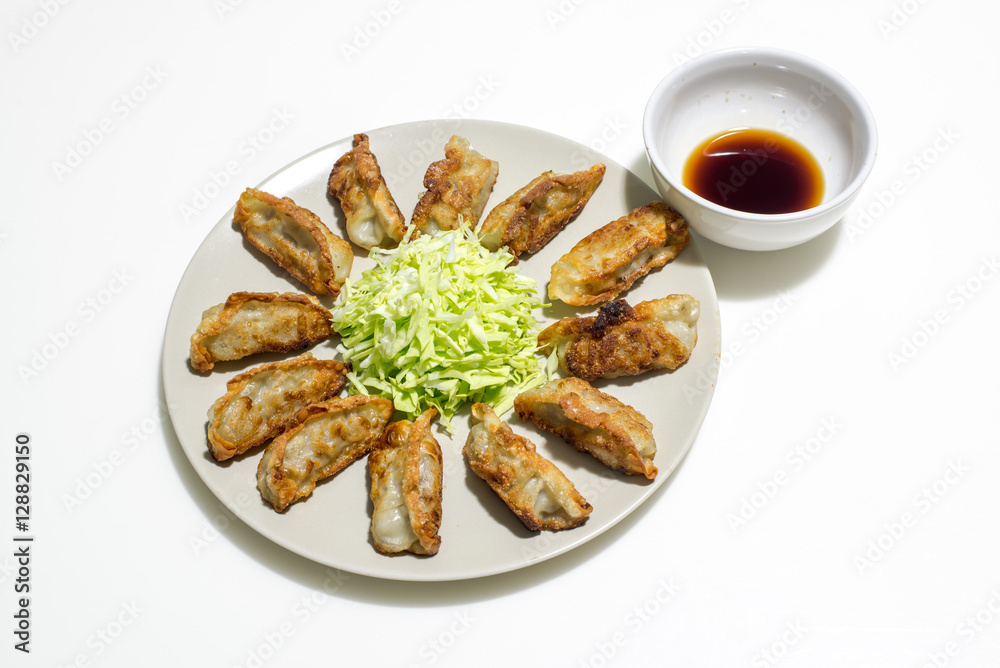 fried gyoza (dumpling) with salad and sauce isolated on white background fried gyoza (dumpling) with salad and sauce isolated on white background