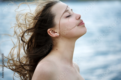 Beautiful woman near sea, wind in the hair