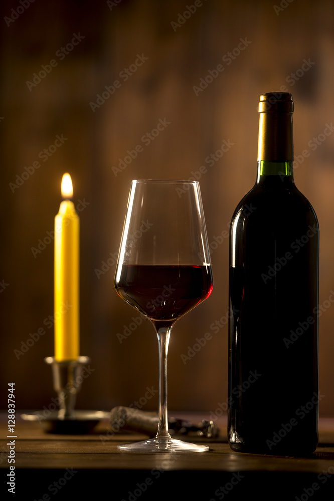 Pouring red wine into wineglass from green bottle