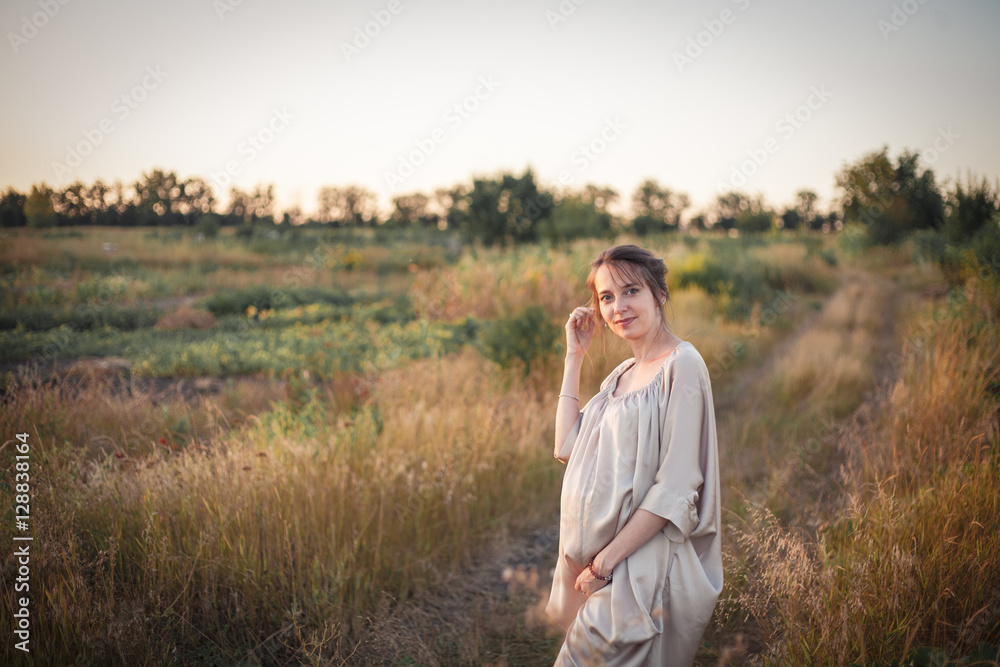 Portrait of a pregnant woman in the sunset light
