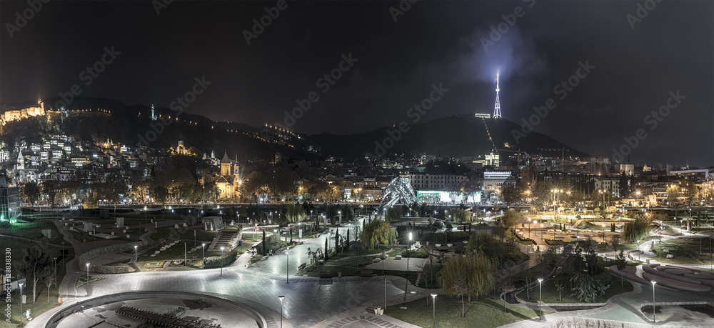 Georgia, Tbilisi. Night view of the recreation park, the TV tower, pedestrian bridge of the world and Narikala fortress.