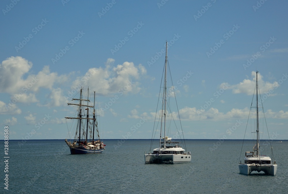 Catamarans and great sailboat anchored in the bay