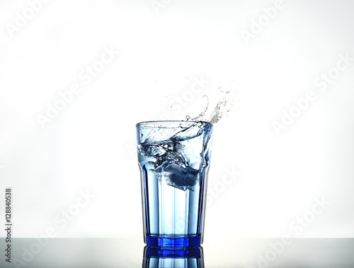 Splash of water with ice in a glass