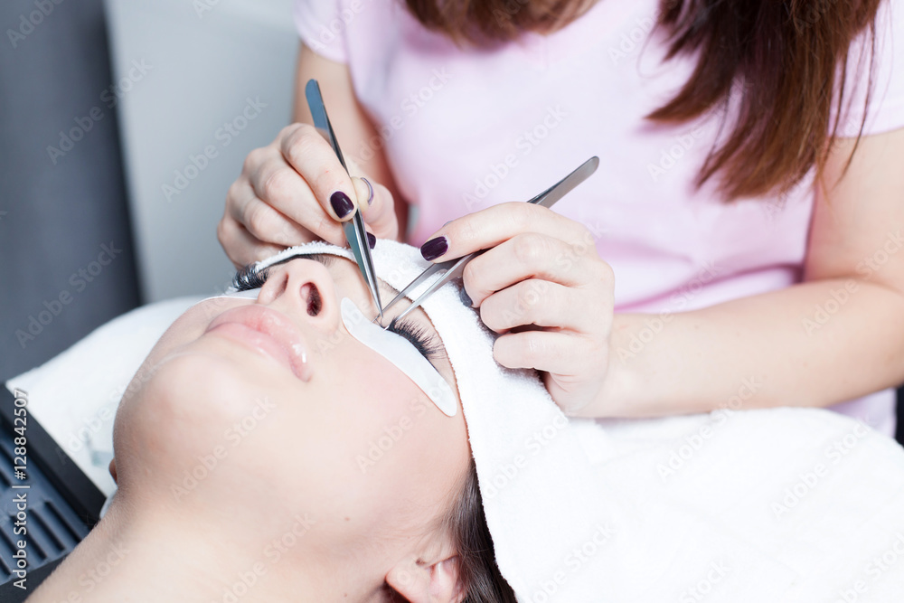 beautician making artificial lashes. eyelash extension procedure