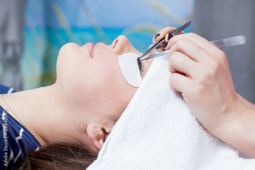 beautician making artificial lashes. eyelash extension procedure