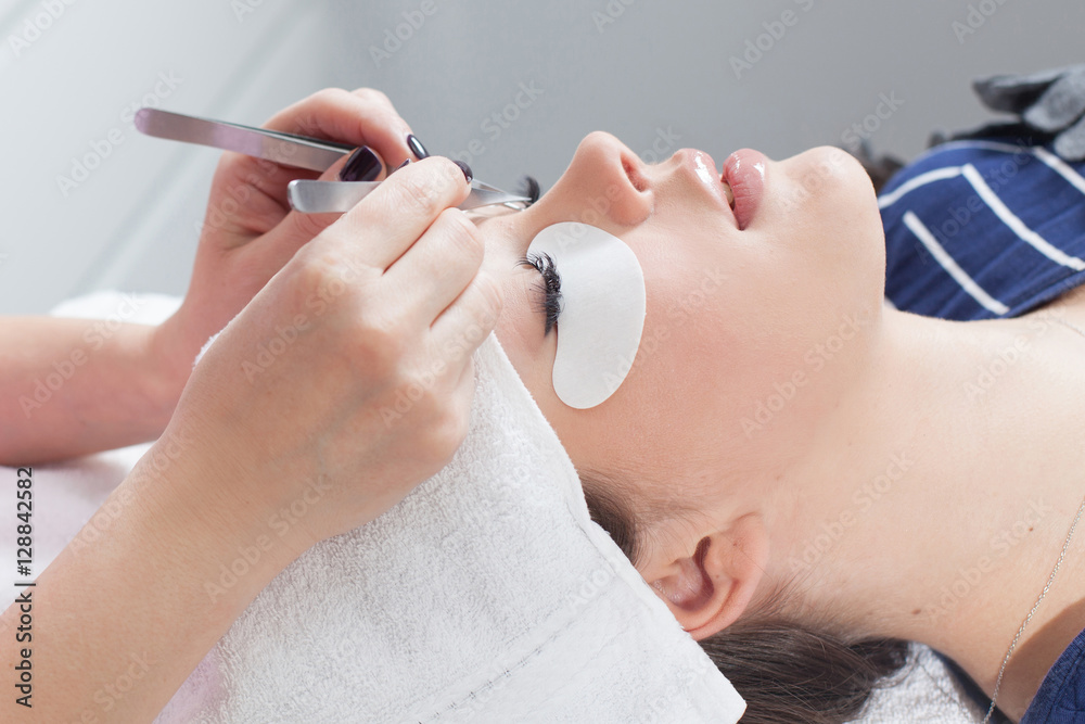beautician making artificial lashes. eyelash extension procedure