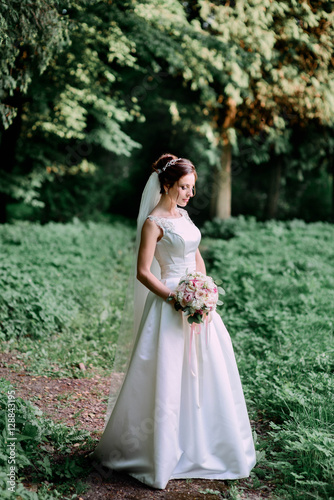 happy and beautiful bride in white dress standing outdoors © IVASHstudio