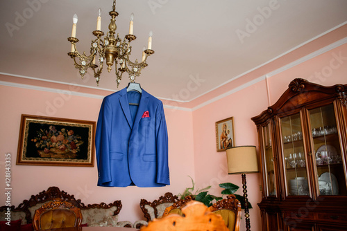 beautiful blue groom's jacket hanging on the chandelier photo
