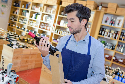 Εκτύπωση καμβά wine merchant who checks the label of a bottle