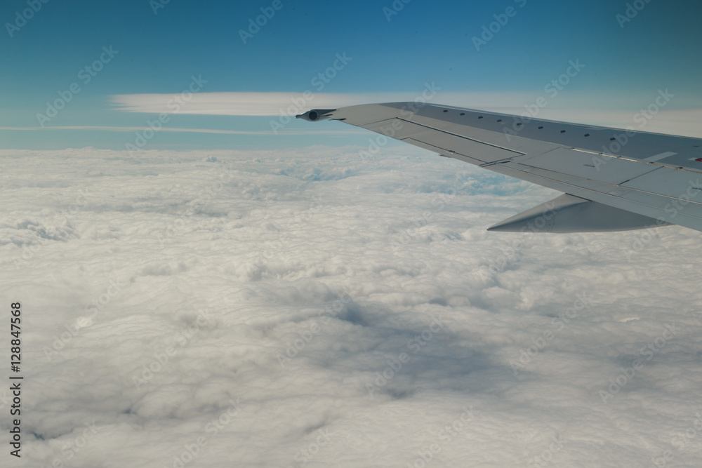Clouds and sky through window of an aircraft.