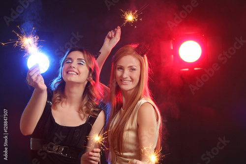 Two beautiful girls having fun at a party.