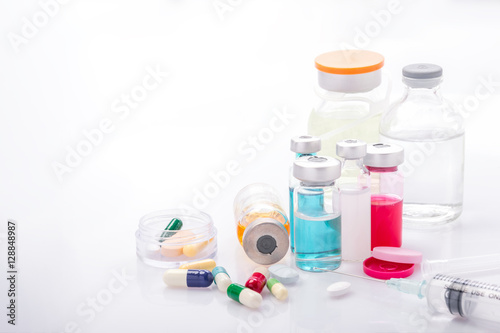 Glass Medicine Vials with syringe pills capsule on white table
