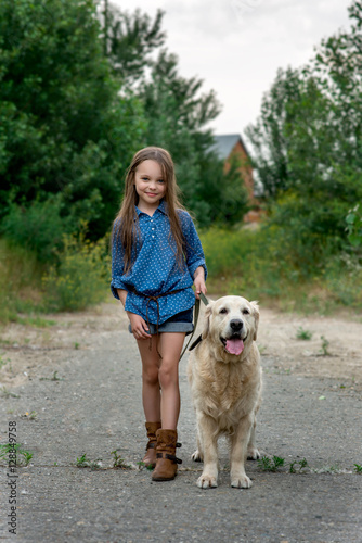 Little girl playing with her big dog outdoors in rural areas 