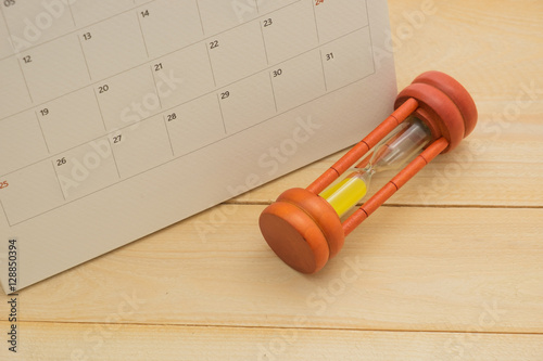 sandglass and calender date on wooden bacground