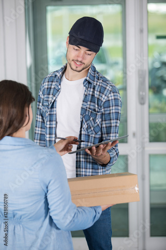 young woman receiving parcel from delivery man photo