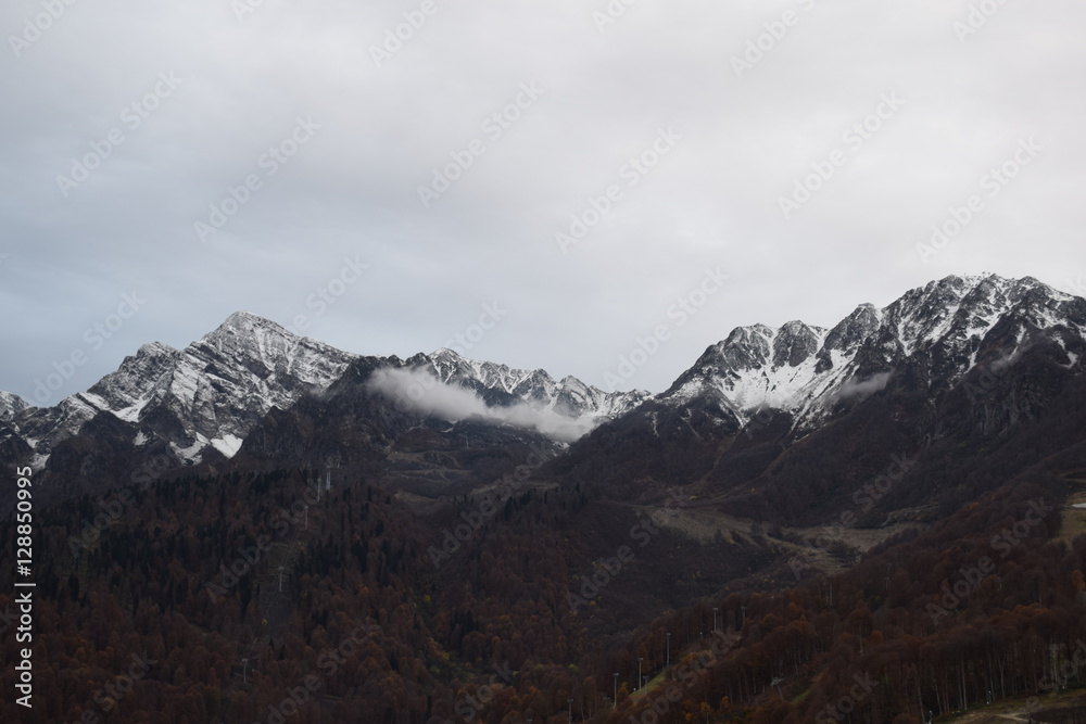 Горный хребет с заснеженными вершинами  Кавказские горы в Сочи