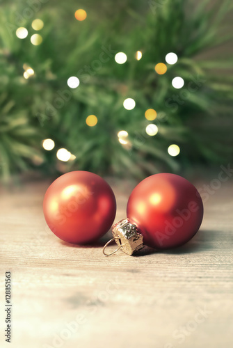 Christmas balls with christmas fir on light wooden background
