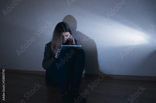 Fotografie young sad vulnerable girl using tablet scared and desperate suffering online abu