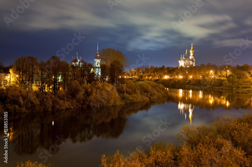 Сity landscape with river by light of evening lamps.