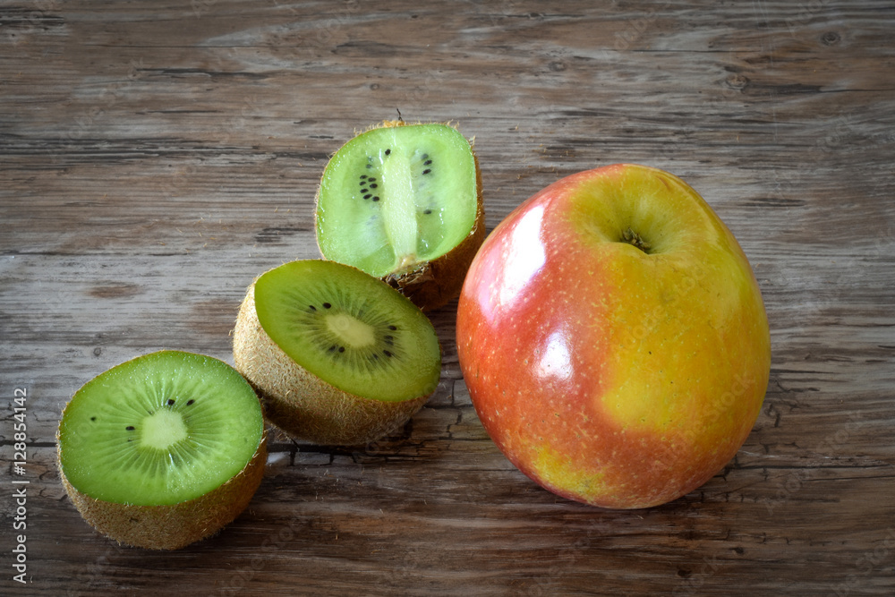 Apple and kiwi isolated on rustic black background. Organic food. Apple and kiwi isolated on rustic black background. Organic food.
