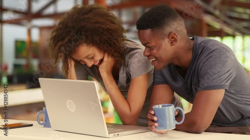 Wallpaper Mural Black millennial couple working together or watching video on laptop in caf_ Torontodigital.ca