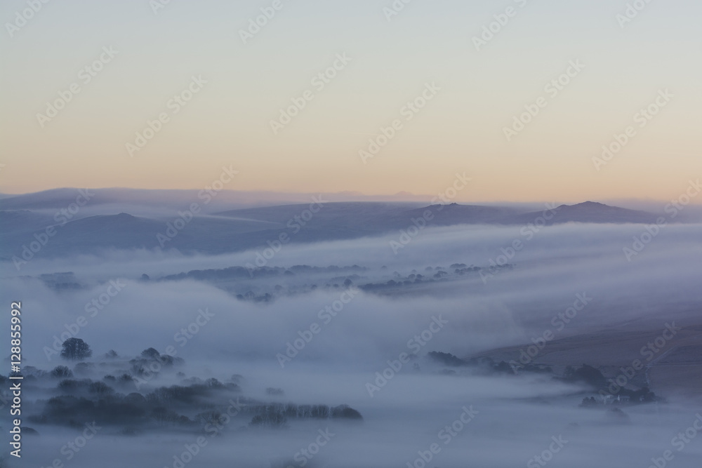 Fototapeta premium sunrise over Dartmoor with mist rolling over hills, Devon, UK