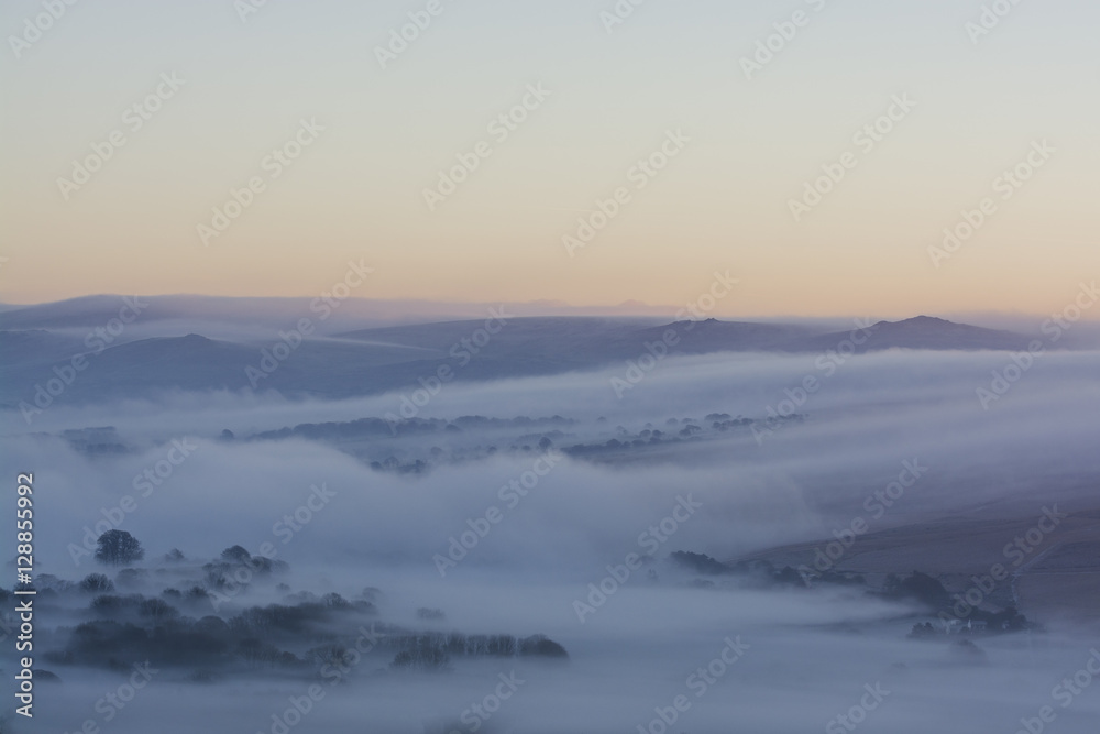 sunrise over Dartmoor with mist rolling over hills, Devon, UK