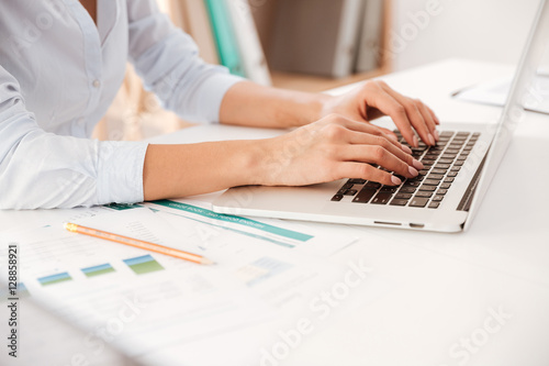Cropped photo of businesswoman using laptop.