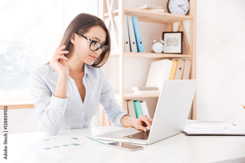 Cute businesswoman wearing glasses using laptop Cute businesswoman wearing glasses using laptop
