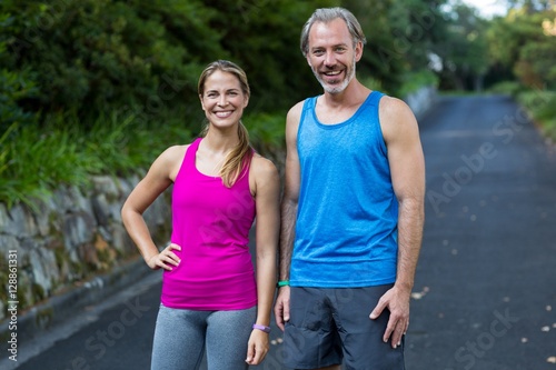 Athletic couple standing on road after jogging