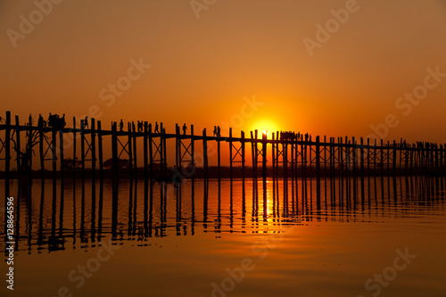 U Bein Bridge at sunset with people crossing Ayeyarwady River  M