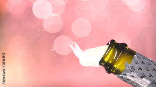 Opening champagne bottle closeup. Sparkling Wine over Holiday Bokeh Blinking Background. Champagne bottle closeup. Success celebrating.