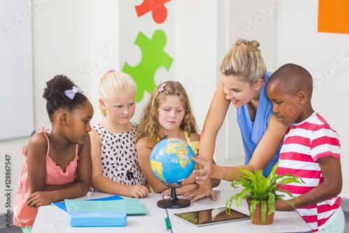 Teacher discussing globe with kids