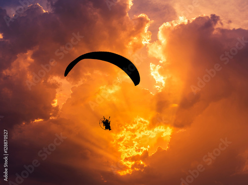 paraglider flying  with paramotor on sunset